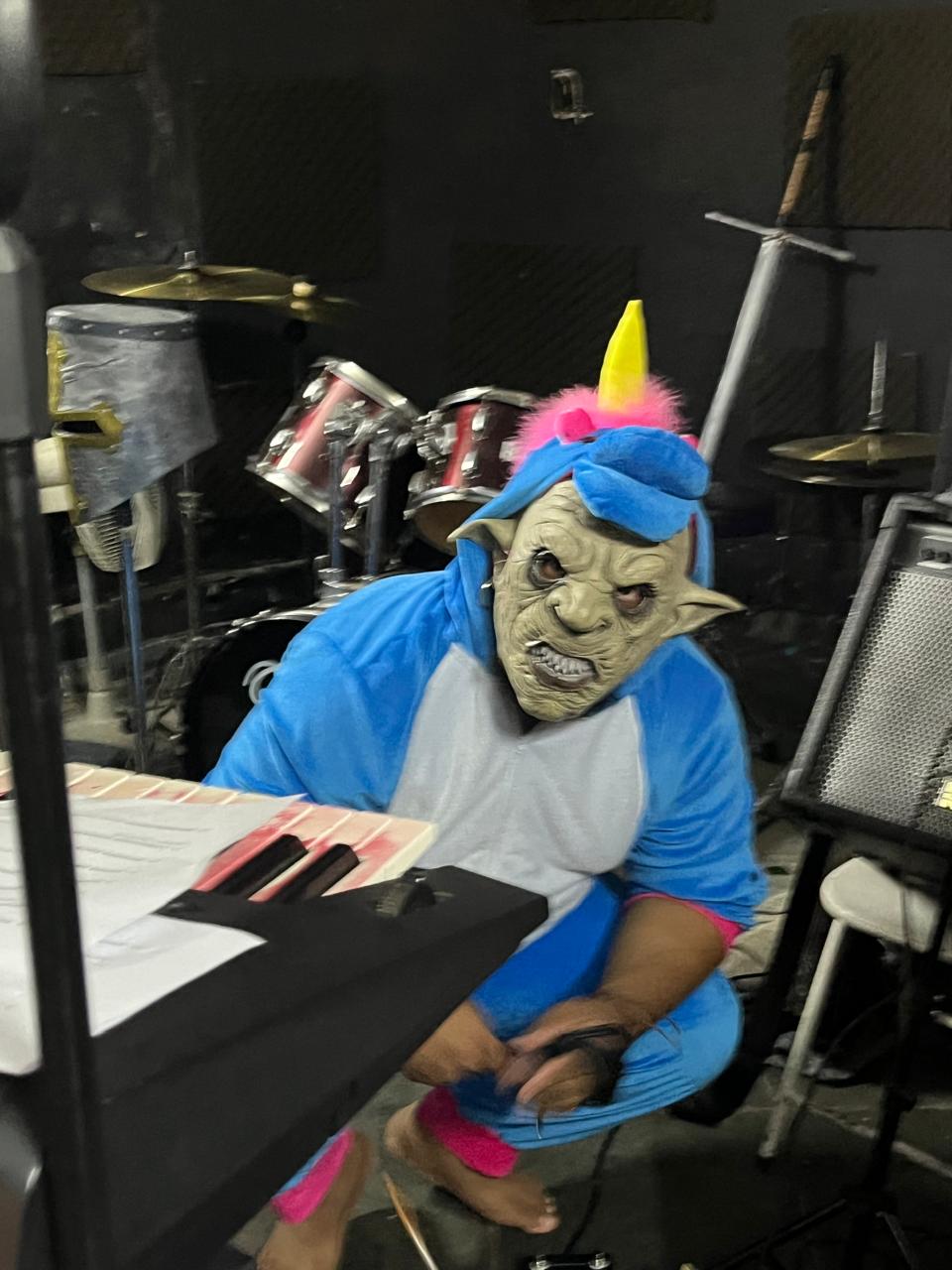 Uni-Orc, orc de capuz de unicórnio, agachado com baixo no estúdio.